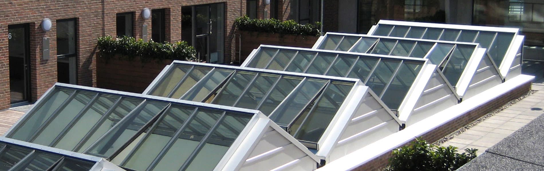 Atrium – mehrere Lichtbänder oder Sattel-Lichtbänder kombiniert zu einem großen Glasdach Atrium - mehrere Lichtbänder oder Sattel-Lichtbänder kombiniert zu einem großen Glasdach
