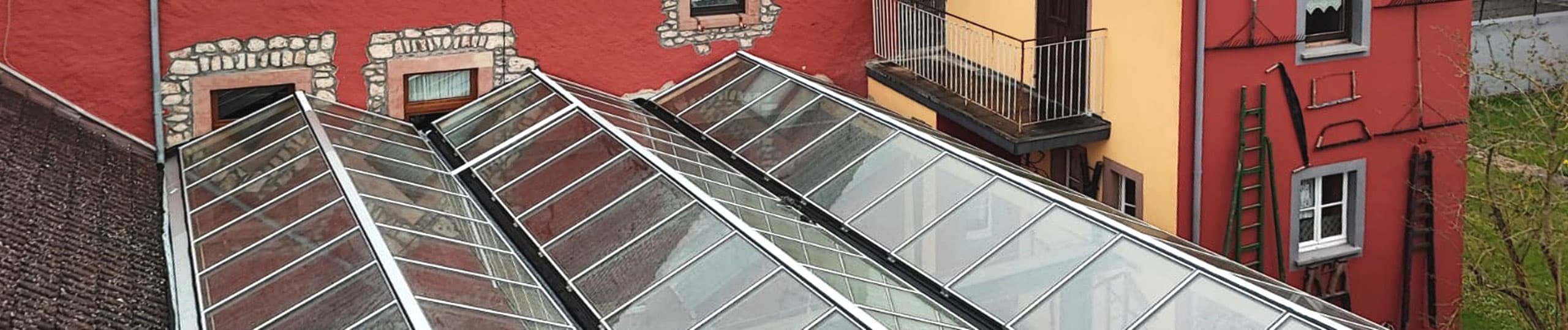 Atrium glazing - continuous rooflights or saddle rooflights combined to form a large glass roof