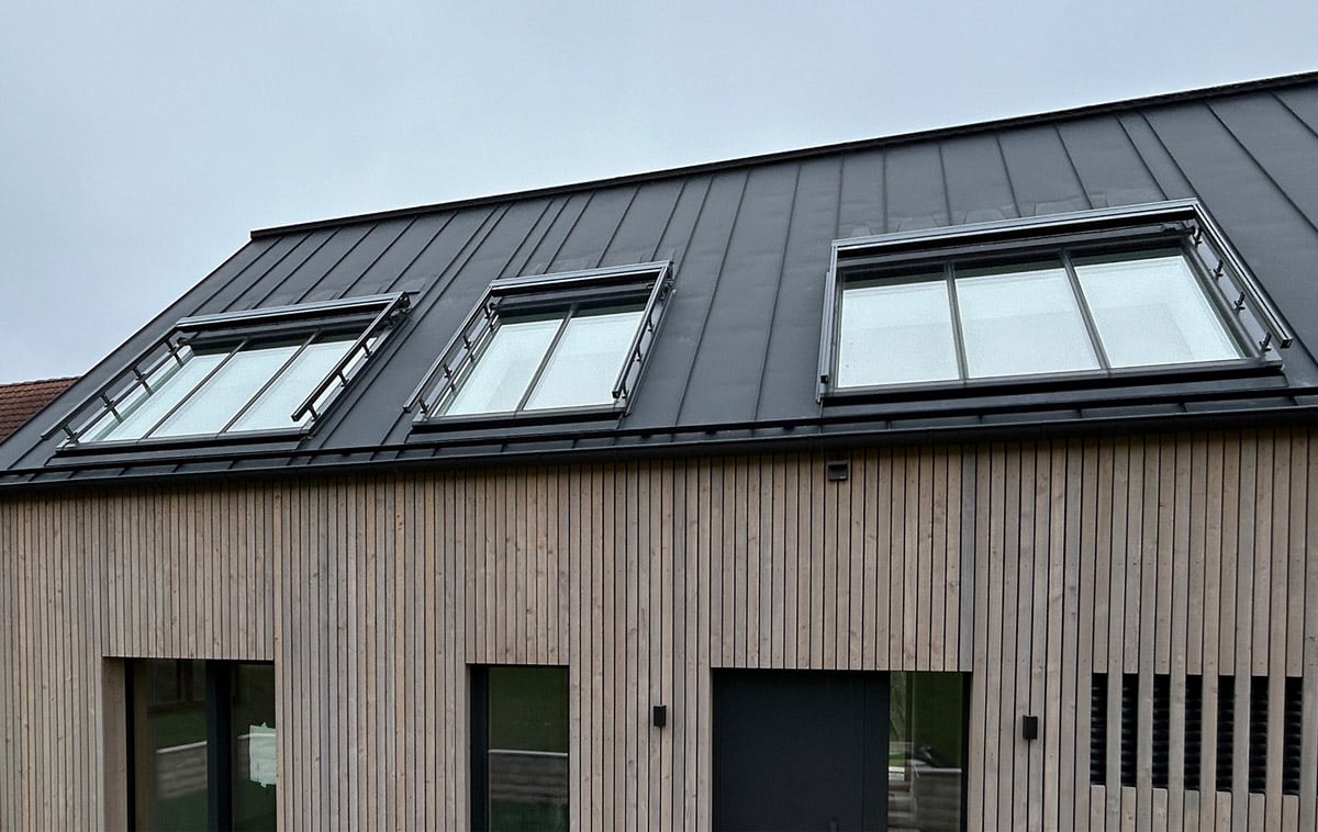 Lichtbandfenster mit Außenbeschattung Drei Lichtbandfenster mit Außenbeschattung auf einem schwarzen Metalldach.