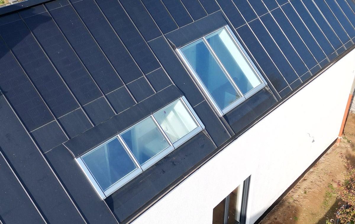 Lichtbandfenster auf Metalldach mit Solarpaneelen Metalldach mit zwei Lichtbandfenstern und integrierten Solarpaneelen